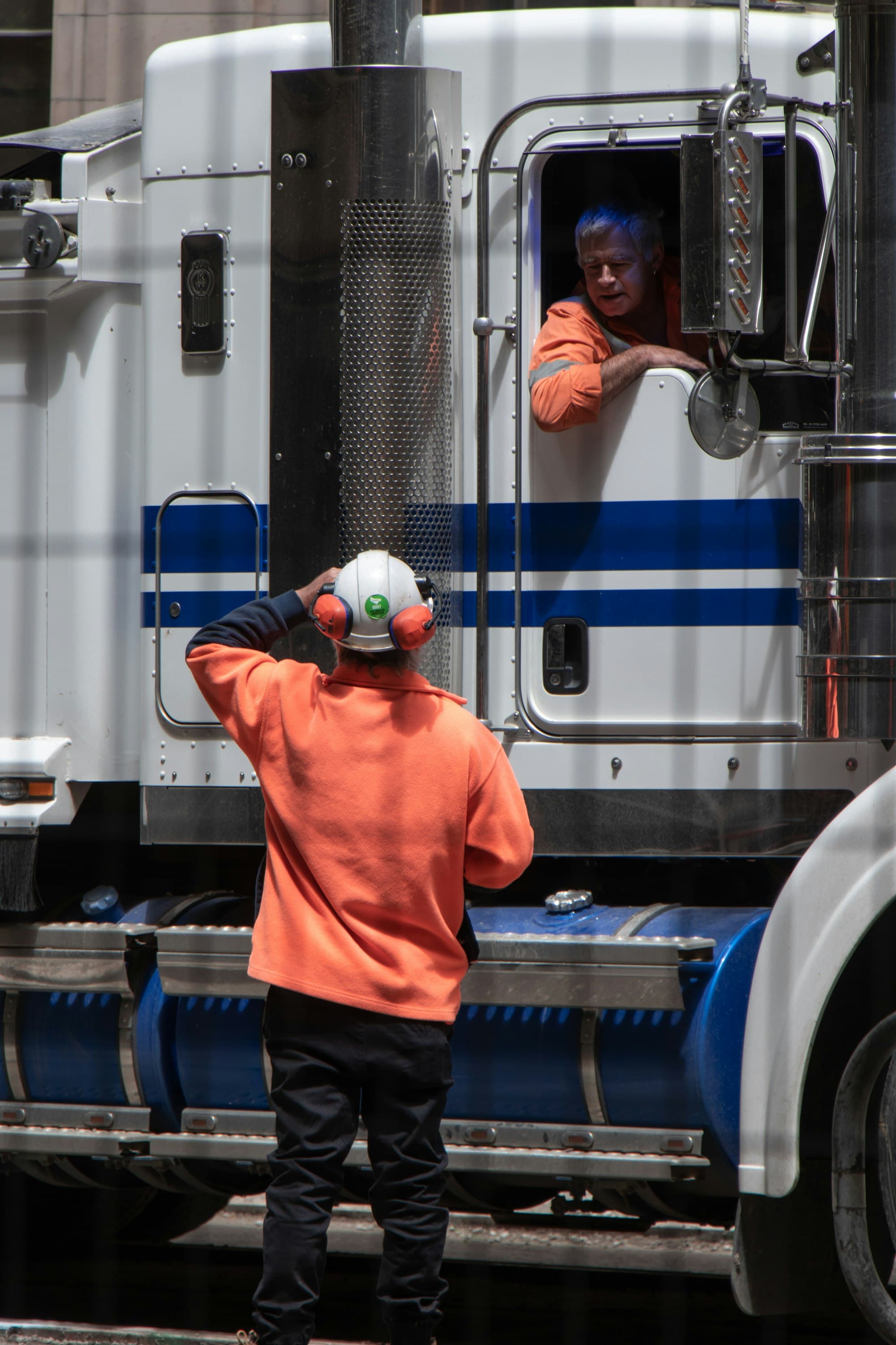 Fleet worker in a hard hat inspecting a semi trailer